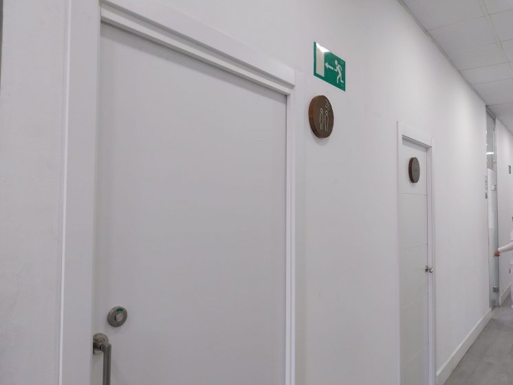 R&oacute;tulos en base de madera lacada y con pictograma en acero inoxidable. Cl&iacute;nica 28 en Sevilla.