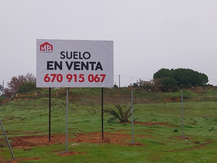 Valla cartelera panelable y rotulada con lona atornillada, para Grupo Inmobiliario MB Dos Hermanas Sevilla.