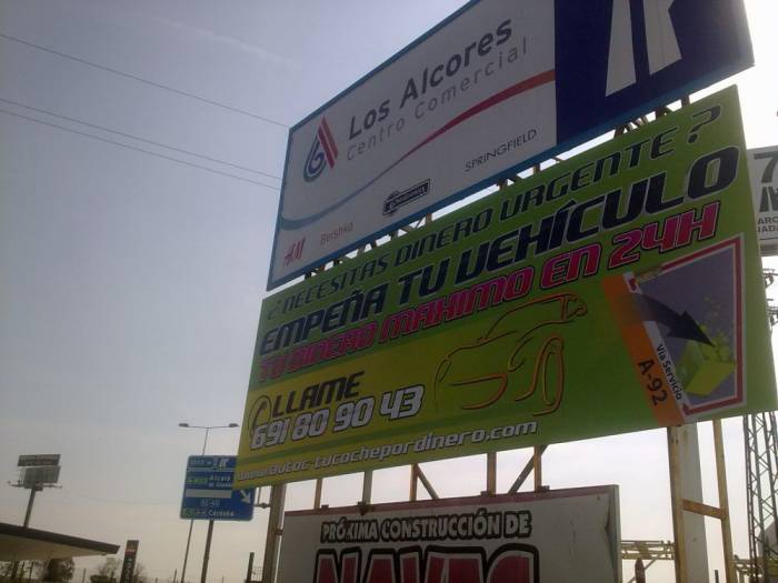 Valla publicitaria o cartelera, así como cartel de obra  panelable y rotulada con vinilo. Autocobra Sevilla