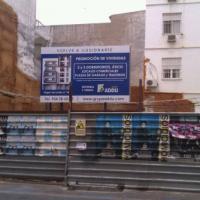 Valla publicitaria o cartelera, así como cartel de obra  panelable y rotulada con vinilo. Grupo Addu, Sevilla