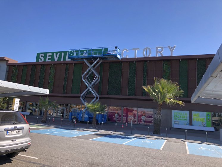 Fondo en chapa microperforada y mallazo de cesped para Sevilla Factory en Dos Hermanas.