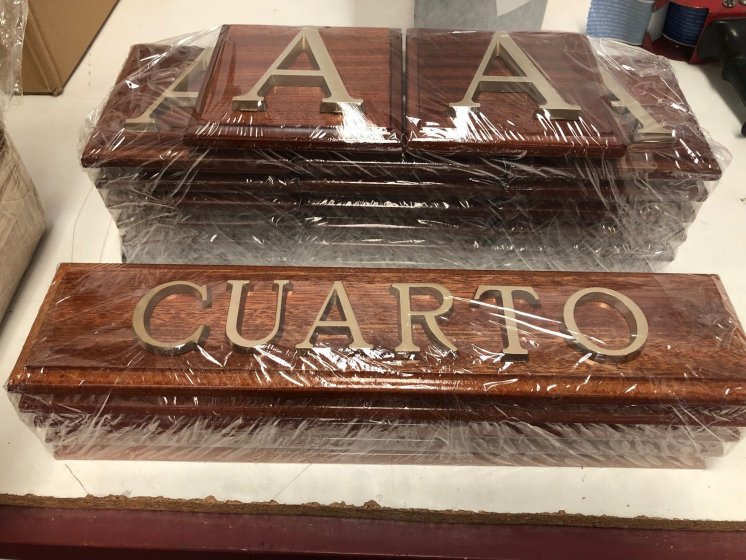 Rótulo cartel en base de madera y letras en latón fundido.