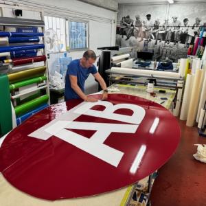 Desmontaje para pintado de textos, logo y placa nueva de metacrilato y su rotulación. Café AB en Sevilla.