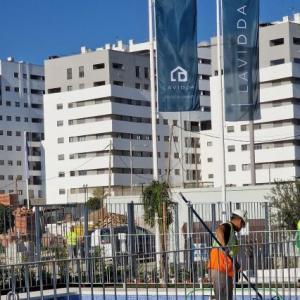 Mástil en fibra de vidrio con potencia y banderas. Dado de hormigón. Para Deacapital en Entrenúcleos Dos Hermanas Sevilla.