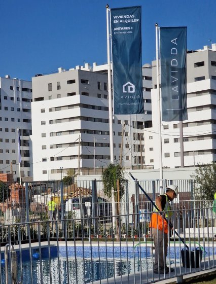 Mástil en fibra de vidrio con potencia y banderas. Dado de hormigón. Para Deacapital en Entrenúcleos Dos Hermanas Sevilla.