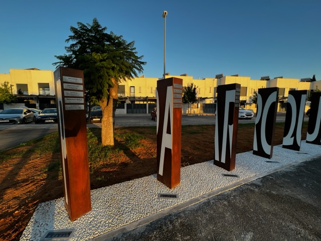 Tótem en acero cortén con texto en aluminio lacado y carteles en acero inoxidable grabados en bajo relieve y patina de tinta negra, para el Ayuntamiento de Dos Hermanas, Sevilla.